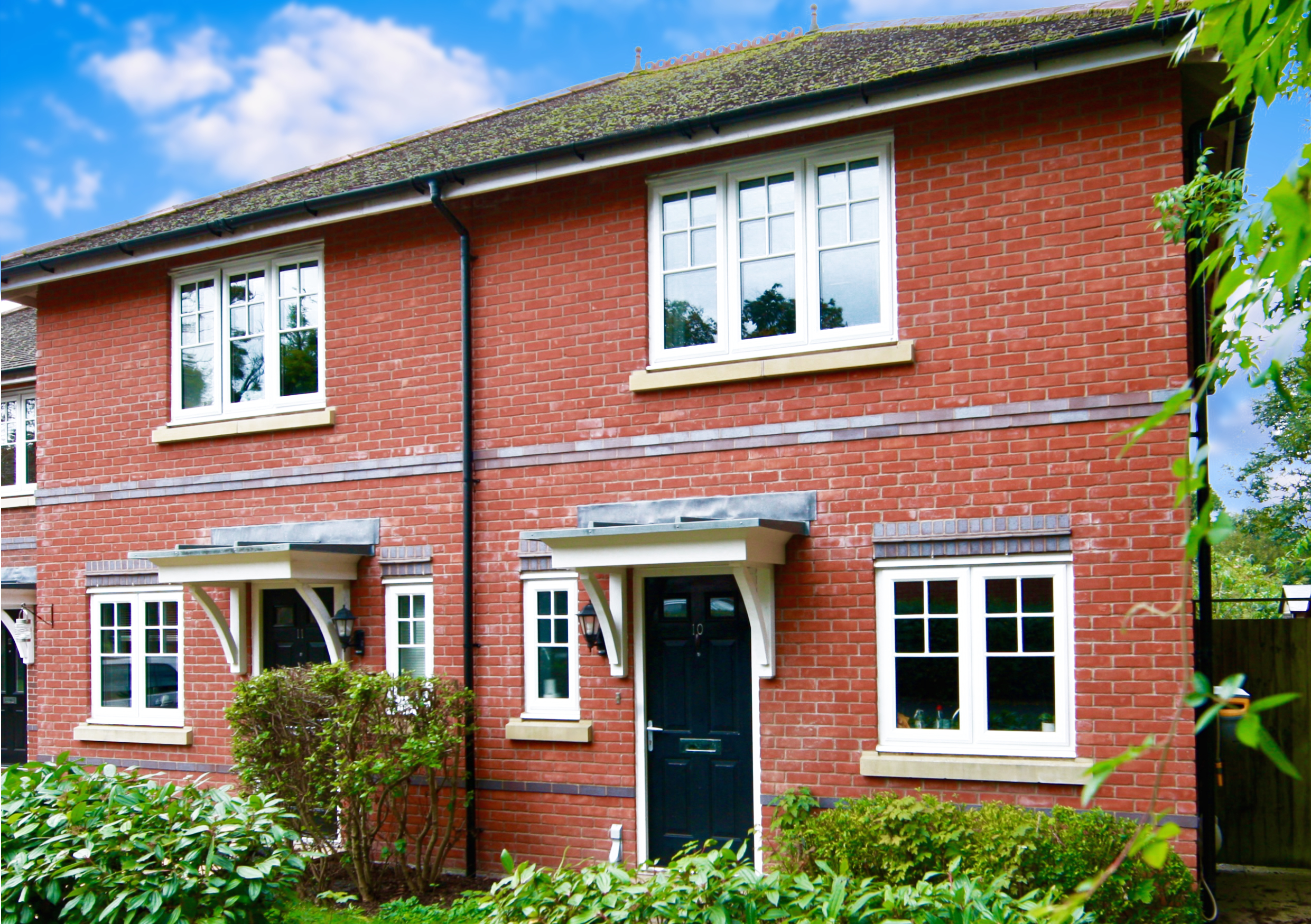 Modest home with blue sky backdrop added to brighten the image